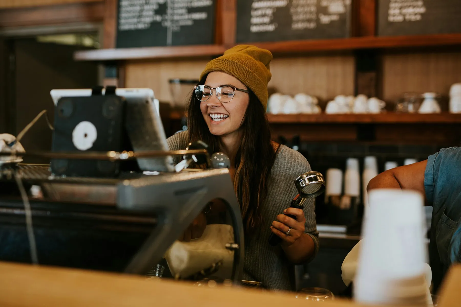 Barista sonriendo mientras prepara un café